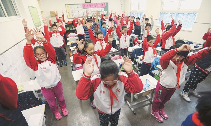 Primary school students exercise inside a classroom as outdoor activities are banned due to heavy smog. Reuters